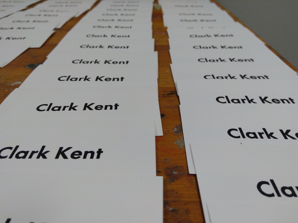 Photo of a collection of freshly-printed Clark Kent business cards,