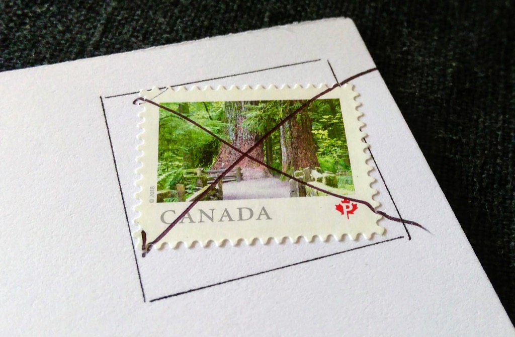 Detail of a postcard stamp cancelled with a pen stroke by Canada Post.