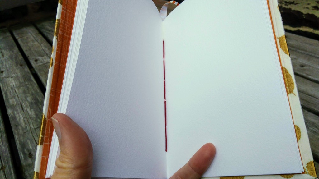 Photo of my hardcover sketchbook showing linen thread in binding.