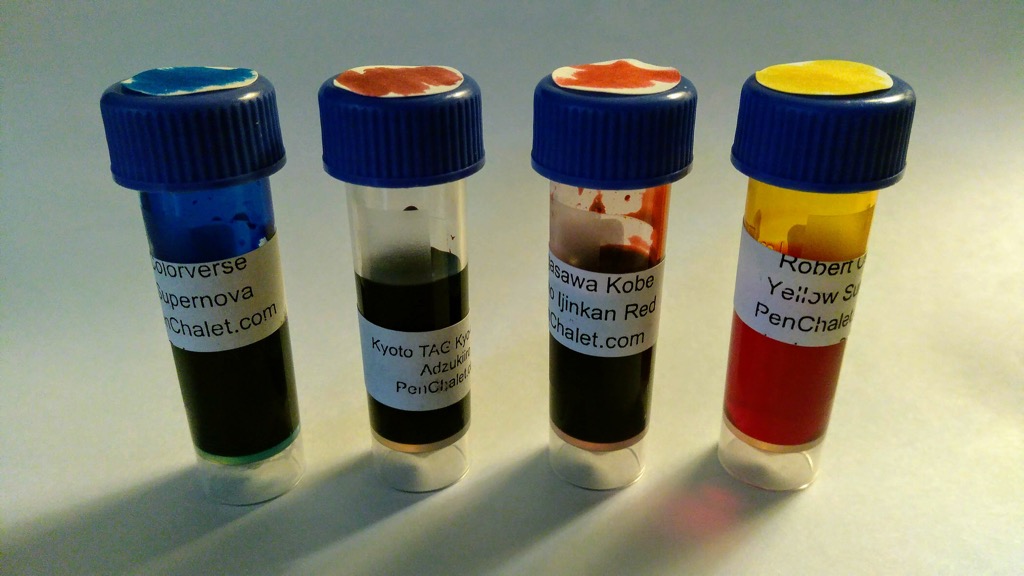 Photo of sample bottles of four colourful fountain pen inks.