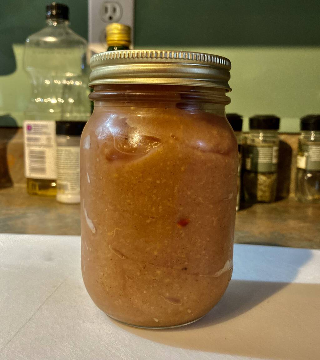 A jar of applesauce sitting on the kitchen counter.