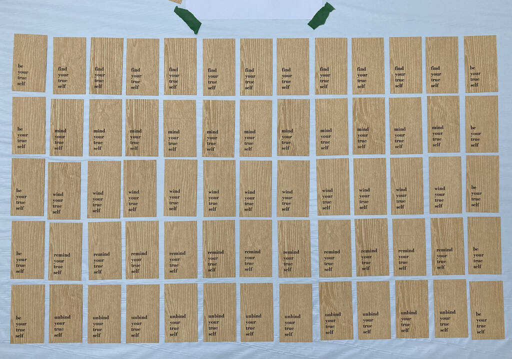 The grid of Artist Trading Cards set out on a table before distribution.