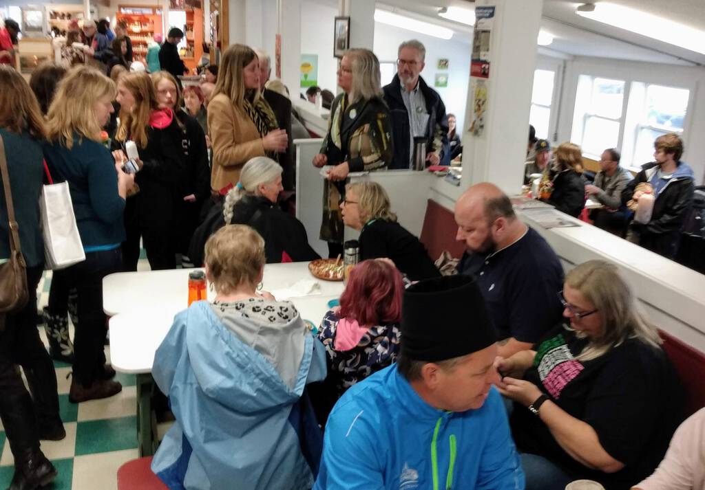 Elizabeth May talks with a voter in the midst of her lunch at the market.