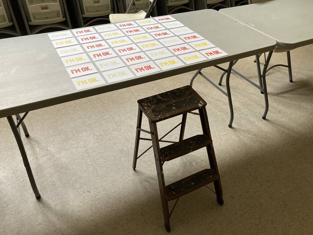 A set of "I'm OK" cards laid out, in different colours, on a table.