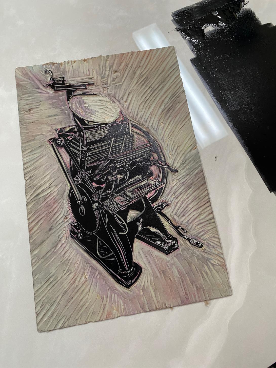 The lino block inked in black ink.