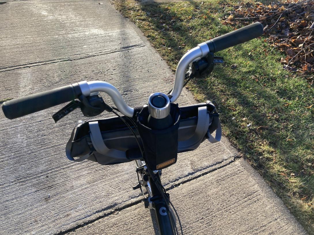 Restrap water bottle holder on my Brompton bicycle, sitting on a sidewalk.