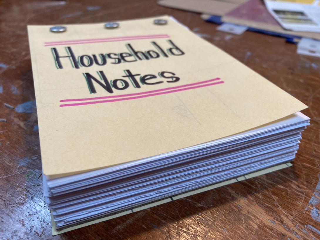 The assembled notebook, with the title "Household Notes" handwritten on the cover with black and green Sharpie.