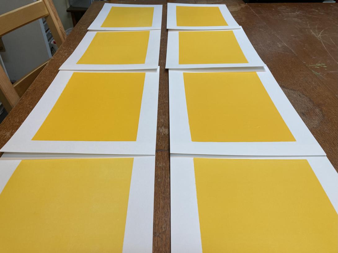 A grid of 8 pieces of white paper, each printed with a solid yellow rectangle.