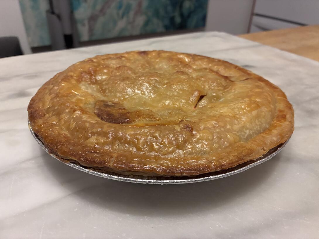 A plum pie sitting on a marble countertop.