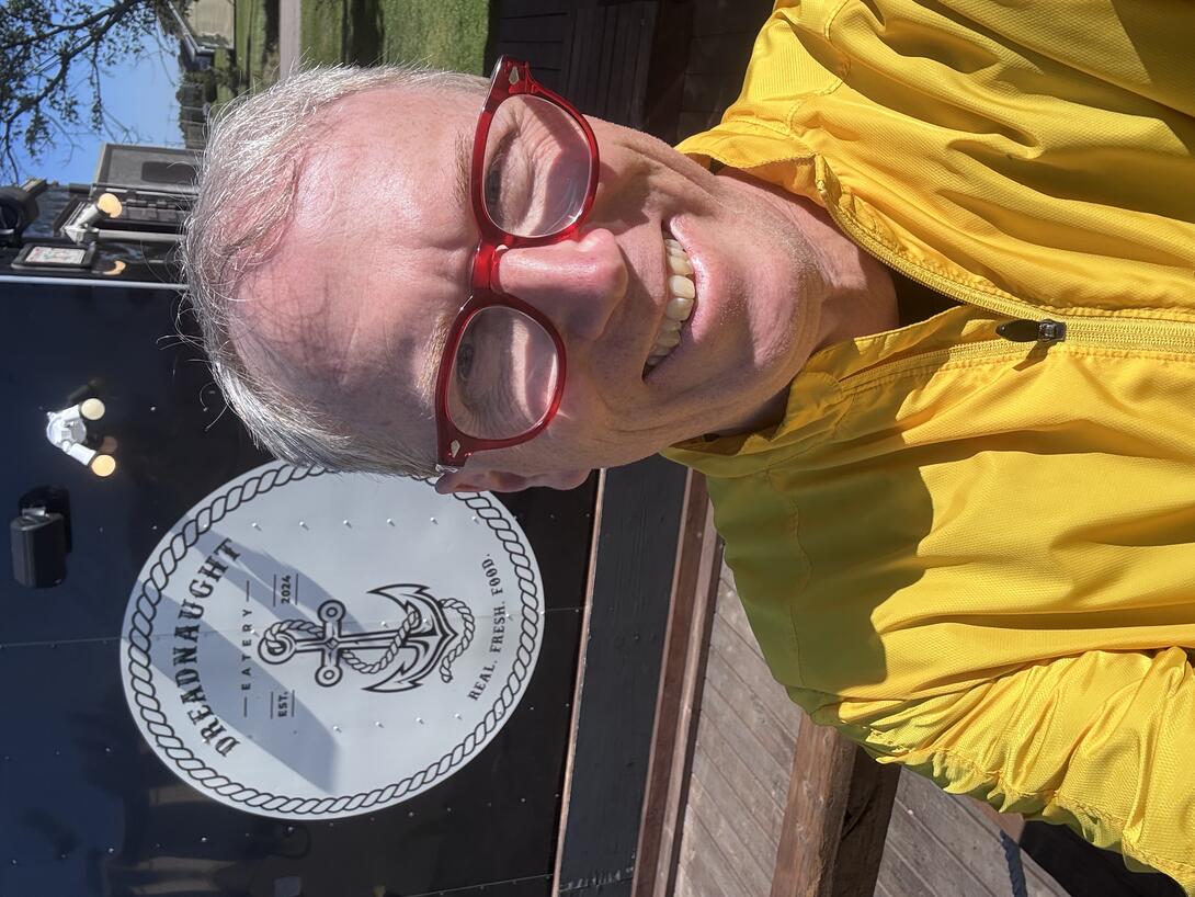 Me, in a selfie, standing in front of the Dreadnaught Restaurant sign.