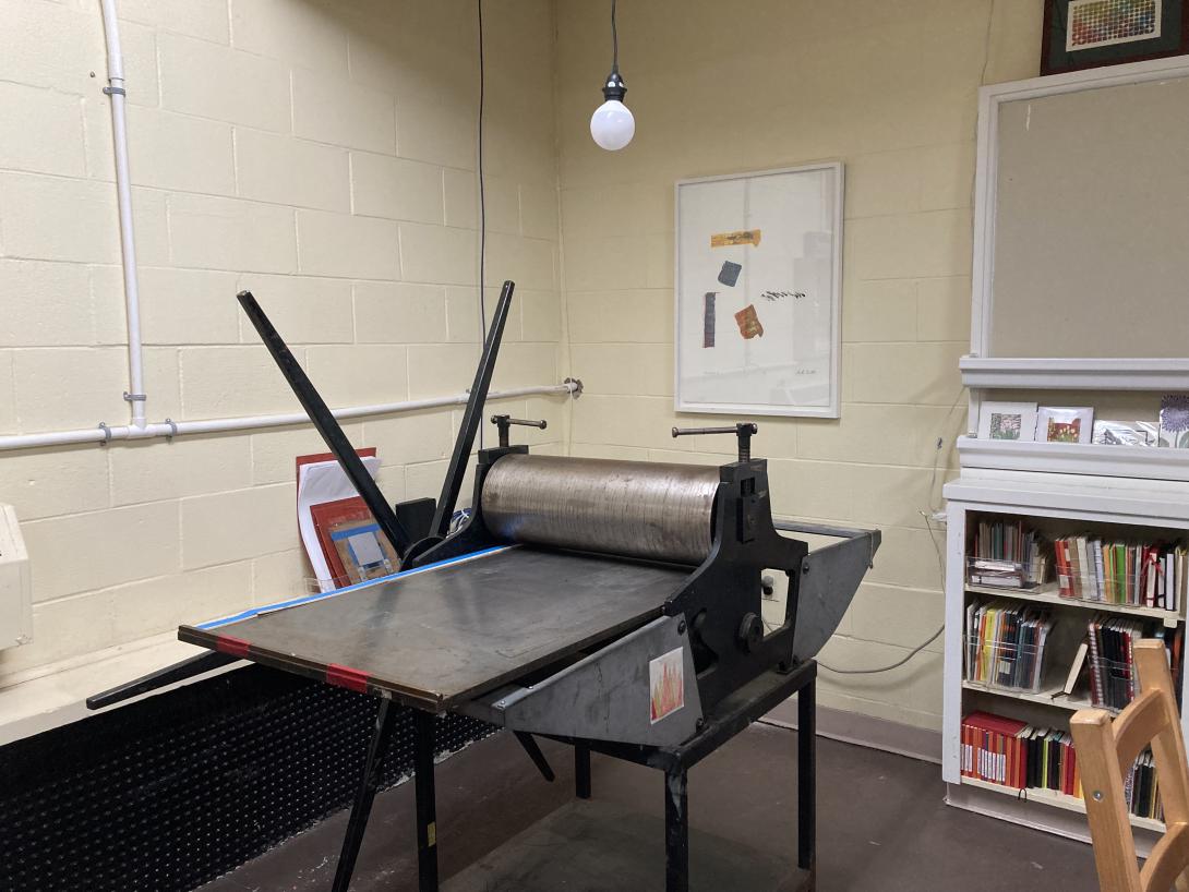 An etching press in the corner of a room.