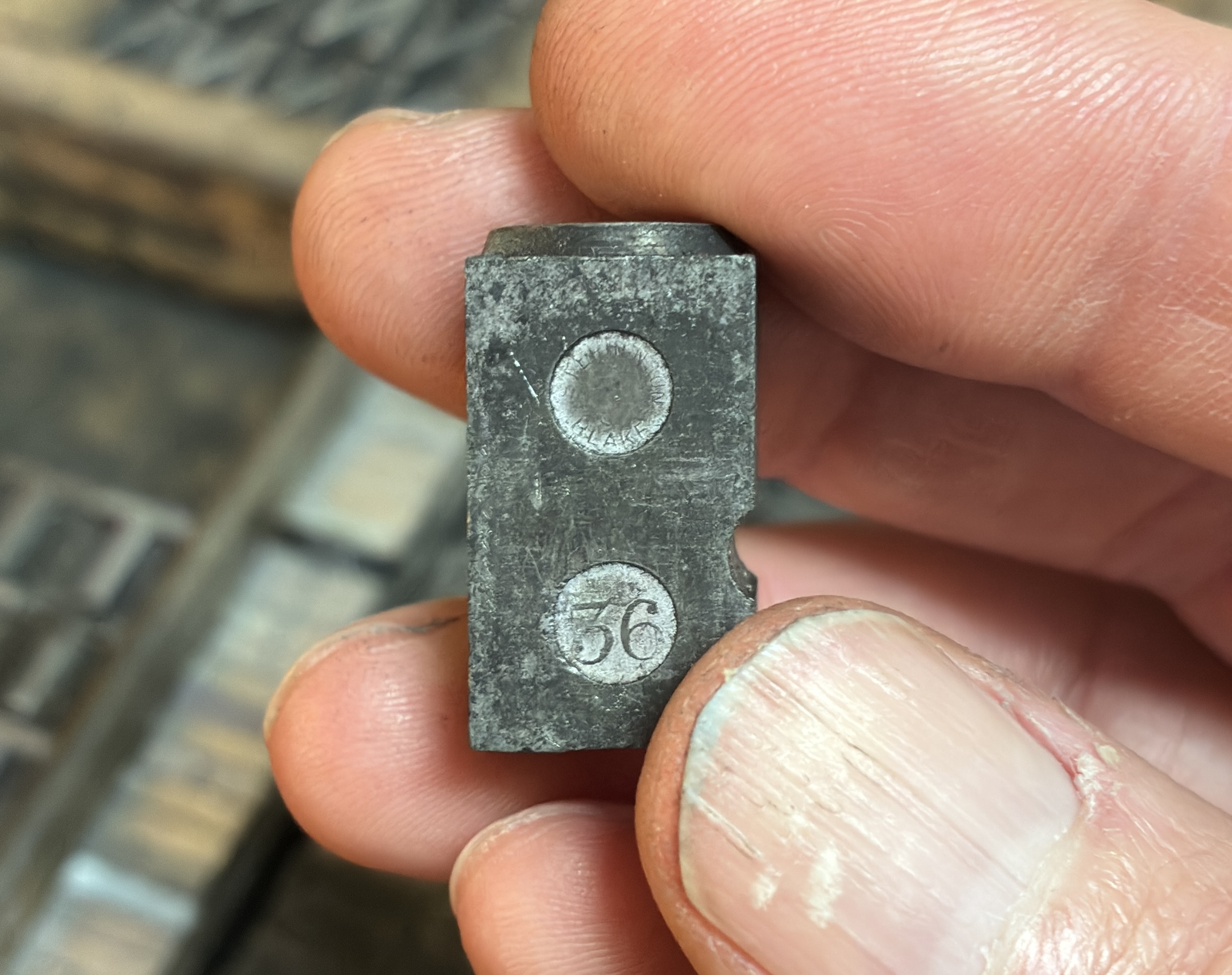 The pin mark on the side of a capital letter O: it reads Stephen Blake on top, and 36 below.