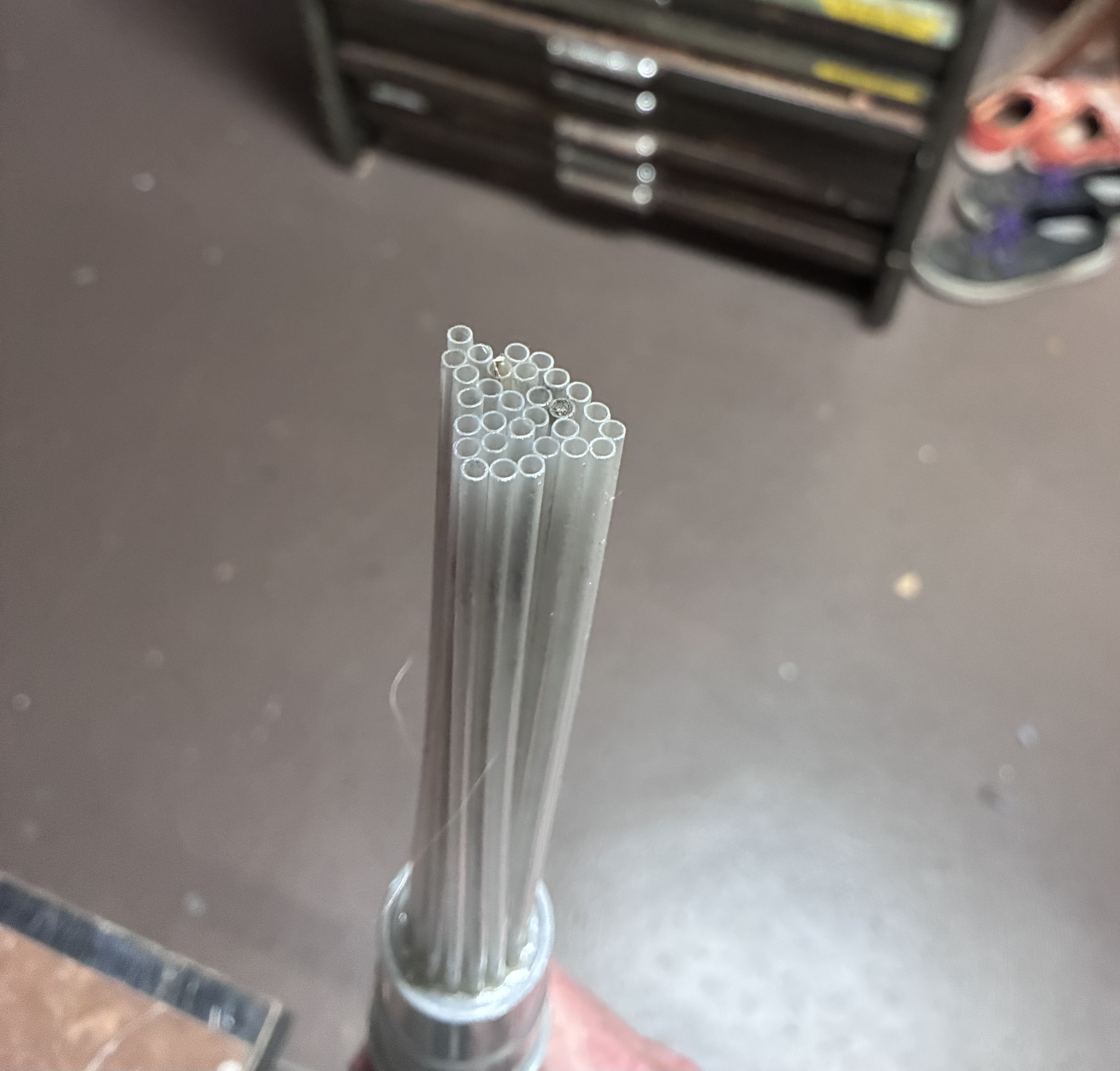 Type vacuum attachment, showing a set of straws attached to a grey plastic body that attaches to a vacuum cleaner.
