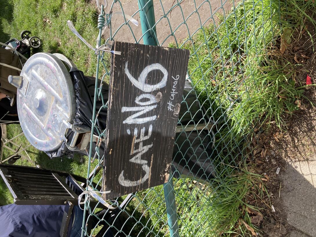 A photo of the Cafe No. 6 sign in the garden.