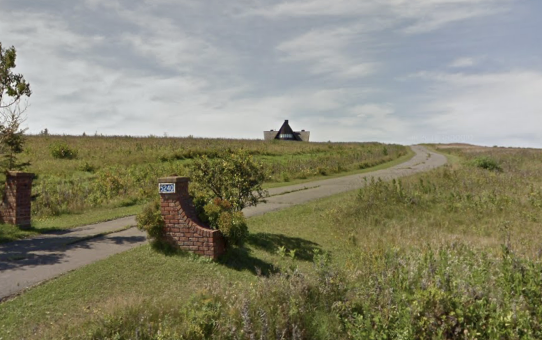 Screen shot from Google Street View of 5240 Route 20 in French River, showing a driveway bracketed by brick posts, leading up to an A-frame house high on a hill.