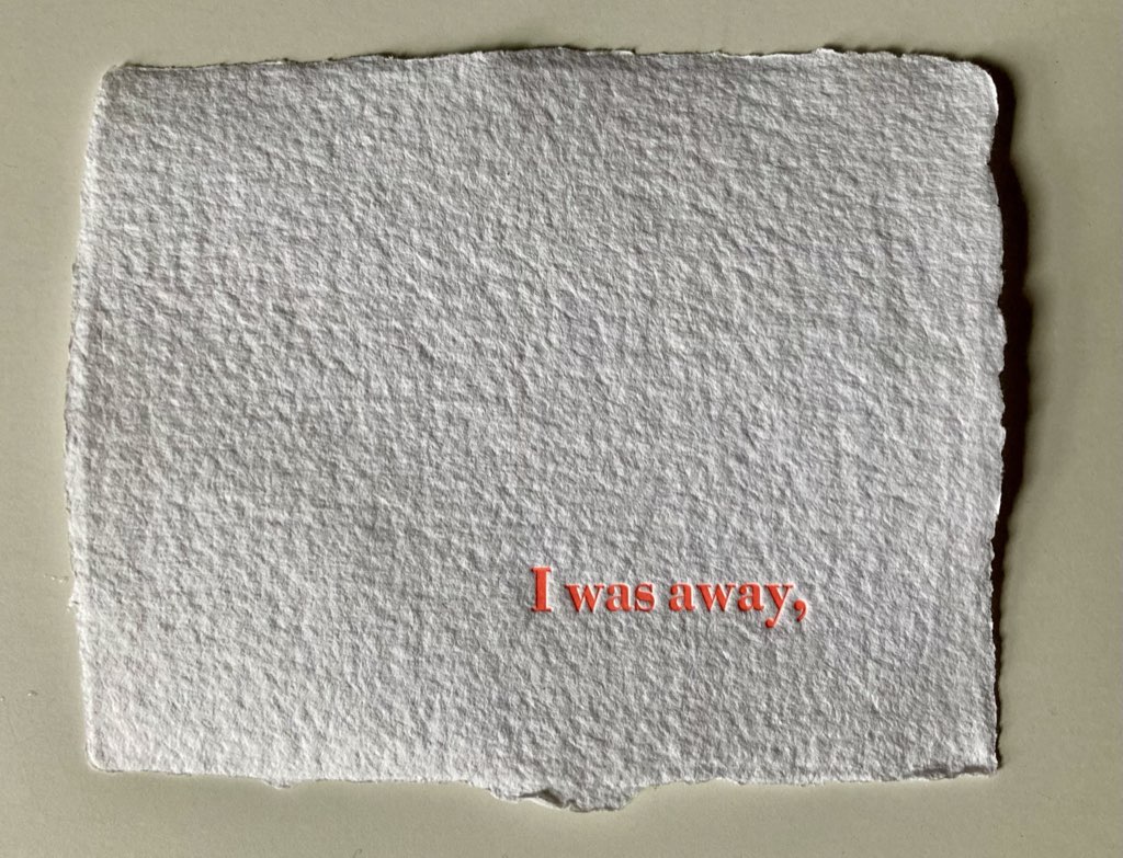 The words "I was away" followed by a comma, printed in orange on a white background, on handmade rag paper
