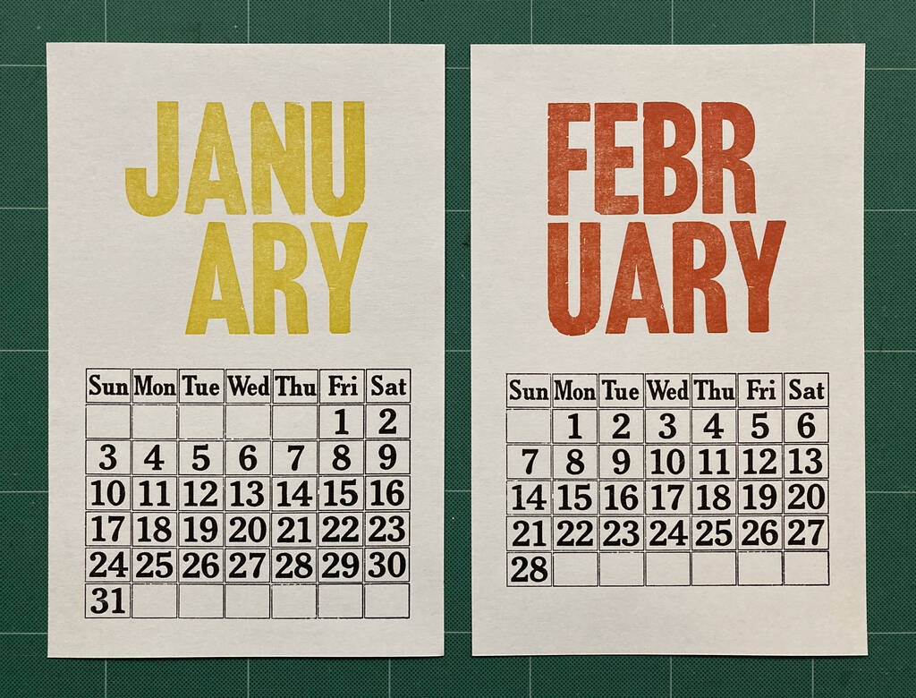 Photo of January and February 2021 calendar cards; January is printed in yellow, February in orange, and the days and dates on both printed in black.