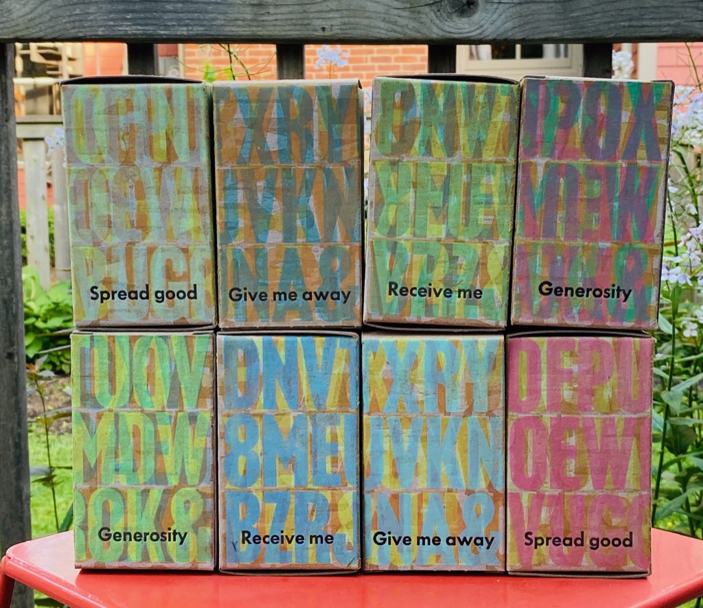 Examples from the June This Box is for Good: 8 printed boxes, each different, stacked on top of each other, 4-on-4, set on a table outside.