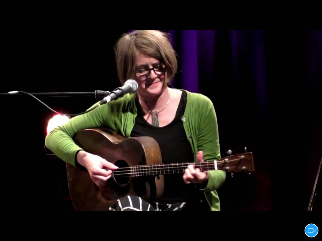 Screen shot of Karine Polwart on Zoom, playing guitar.