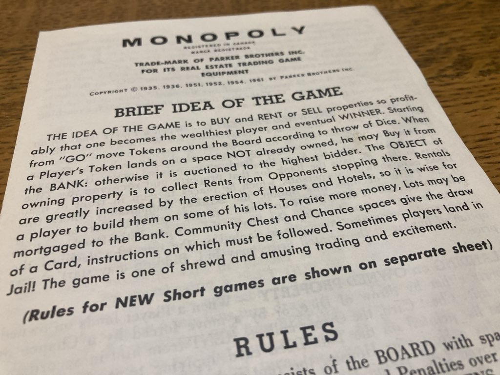 A photo of the top of the first page of an older copy of the rules of Monopoly. The rules read: "BRIEF IDEA OF THE GAME THE IDEA OF THE GAME is to BUY and RENT or SELL properties so profitably that one becomes the wealthiest player and eventual WINNER. Starting from "GO" move Tokens around the Board according to throw of Dice. When a Player's Token lands on a space NOT already owned, he may Buy it from the BANK: otherwise it is auctioned to the highest bidder. The OBJECT of owning property is to collect Rents from Opponents stopping there. Rentals are greatly increased by the erection of Houses and Hotels, so it is wise for a player to build them on some of his lots. To raise more money, Lots may be mortgaged to the Bank. Community Chest and Chance spaces give the draw of a Card, instructions on which must be followed. Sometimes players land in Jail! The game is one of shrewd and amusing trading and excitement. (Rules for NEW Short games are shown on separate sheet)"