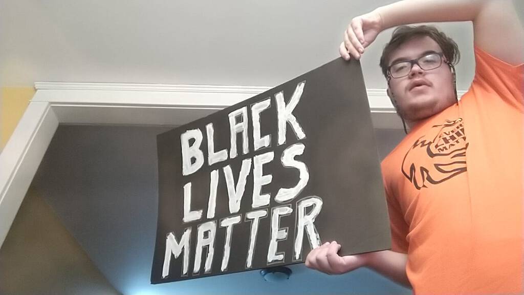 Oliver in his Orange Shirt Day short, carrying a Black Lives Matter placard.