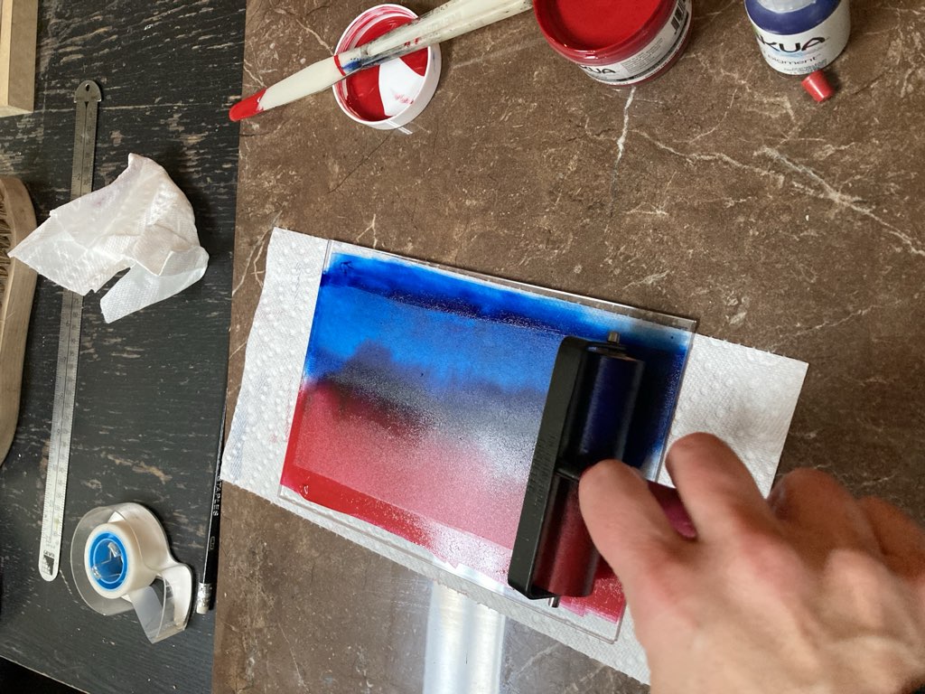 Rainbow rolling red and blue into together on a sheet of glass.