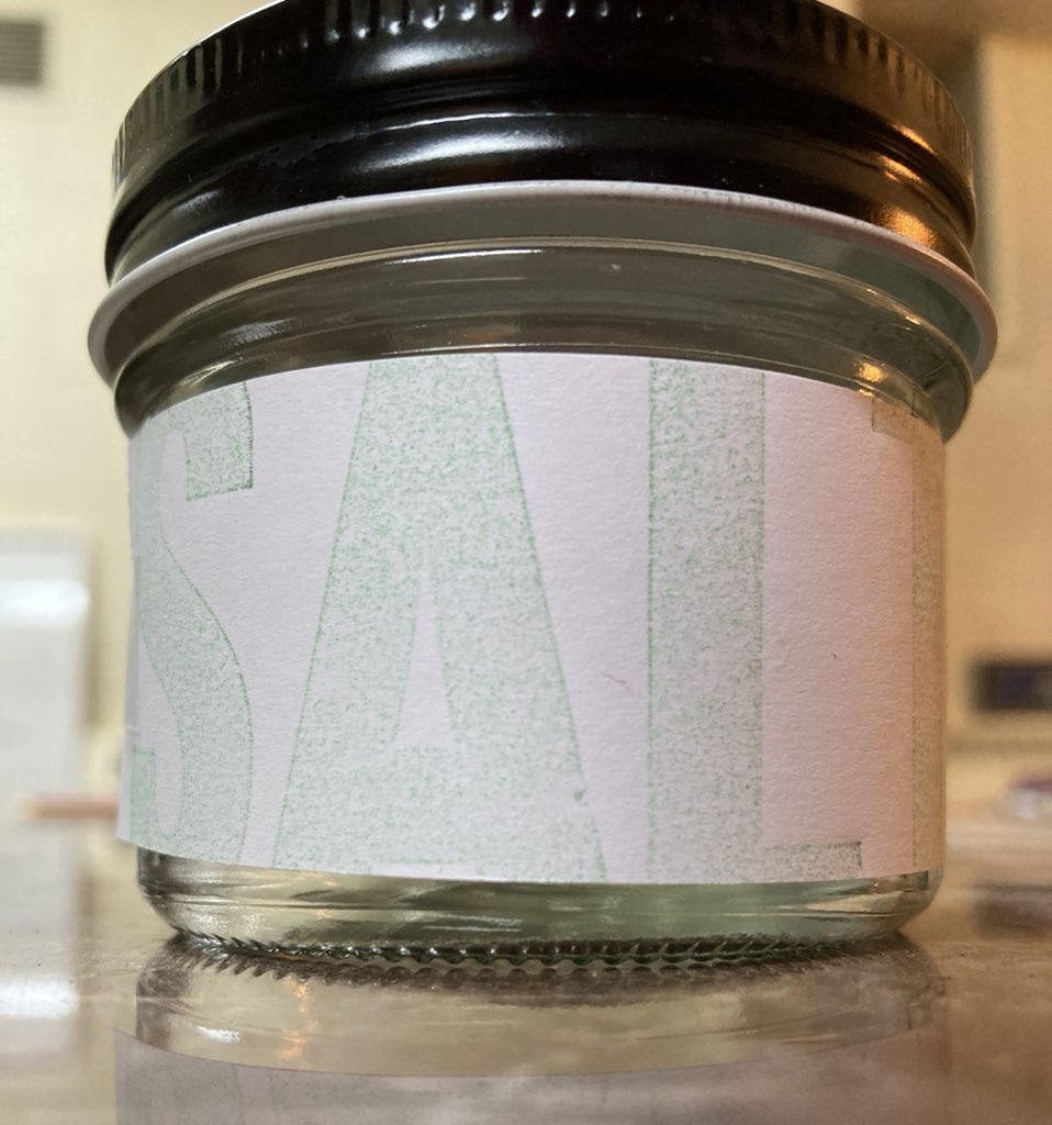 The word SALTY, in rough green print, on a white label, stuck to a small jar.