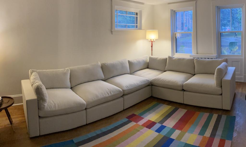 The finished, assembled Cozey sectional in my living room, on hardwood floors, with a multi-coloured rug.