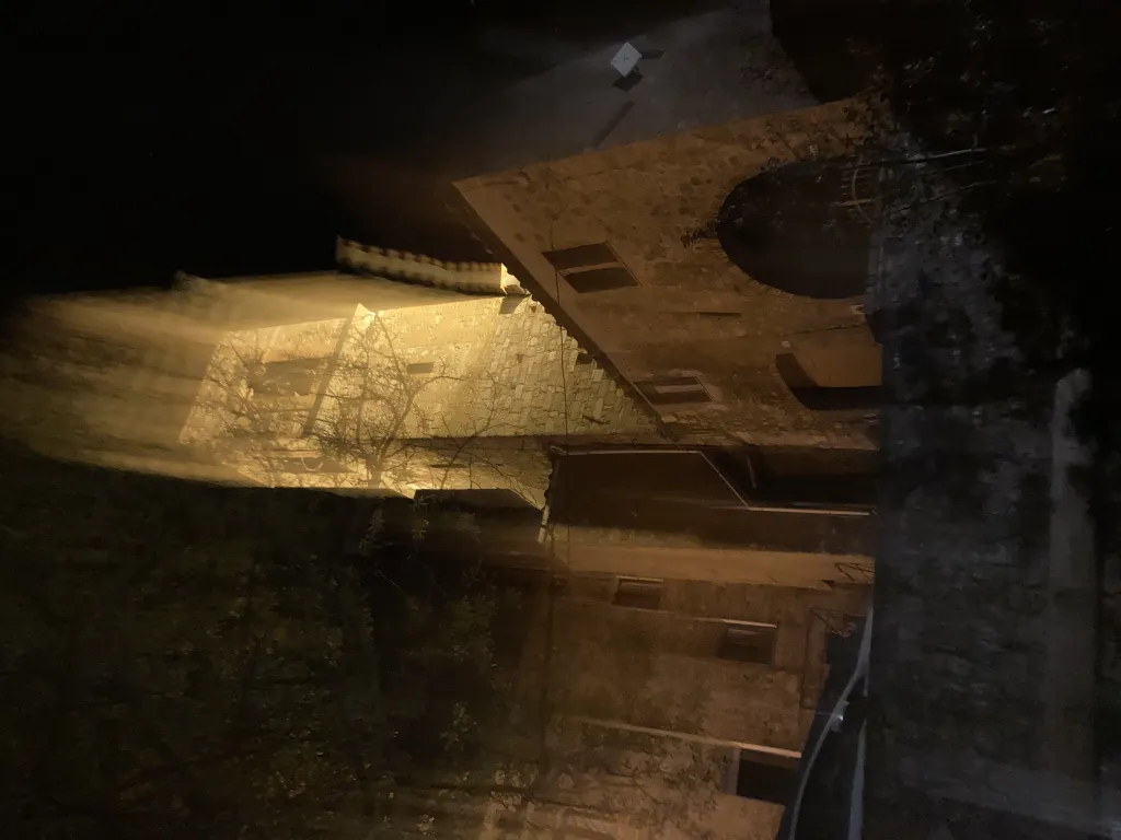 A blurry photo of a bell tower at night.