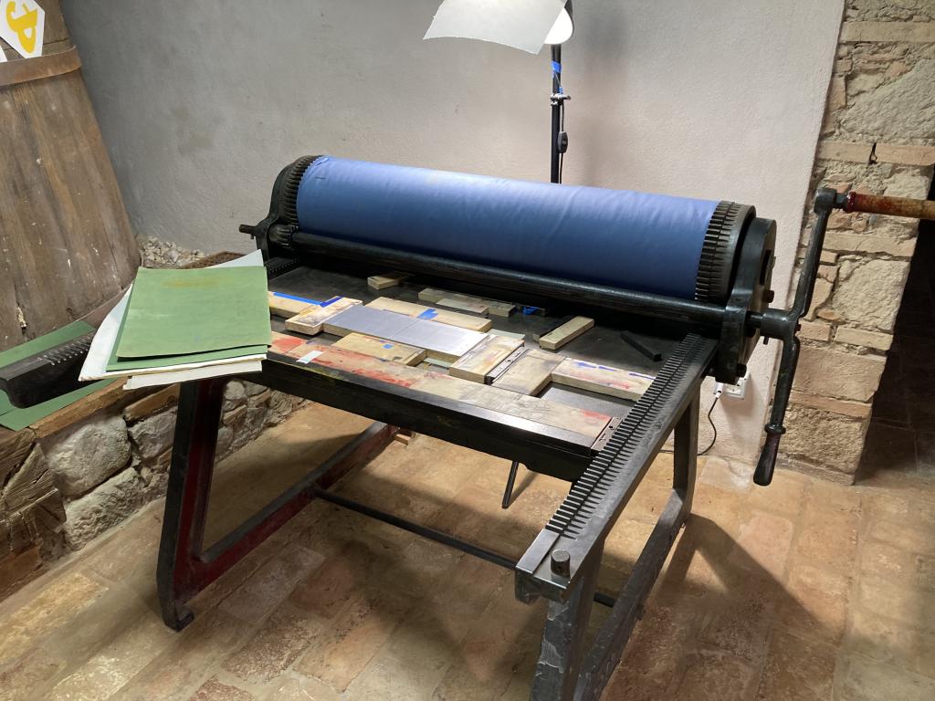 A flatbed press with two lino blocks set up to print a solid silver colour. 