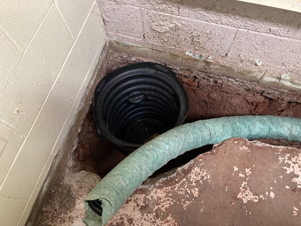 The hold in the corner of my shop where a sump pump would eventually be set.