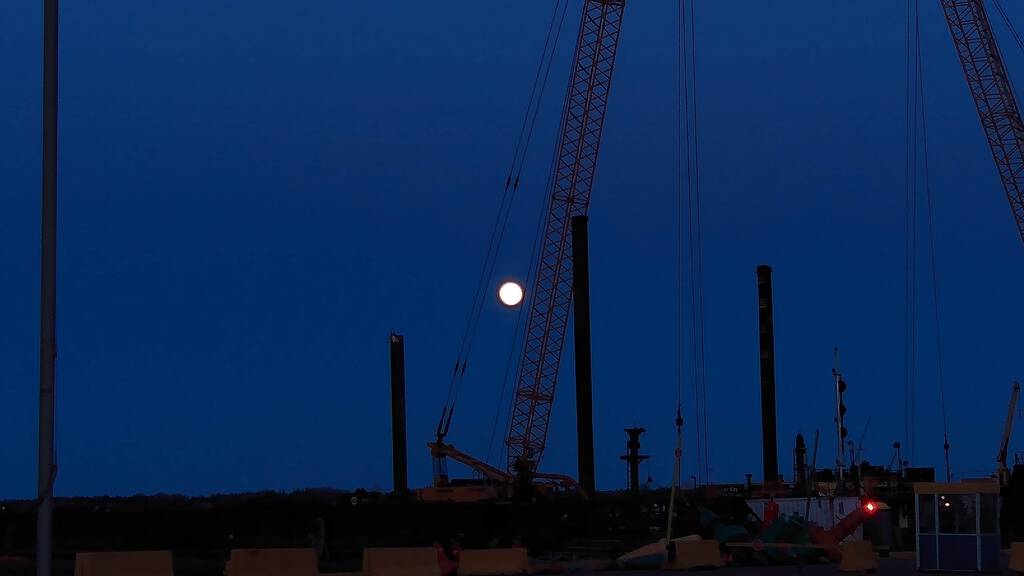 Photo of the Pink Moon behind a crane at Charlottetown waterfront.