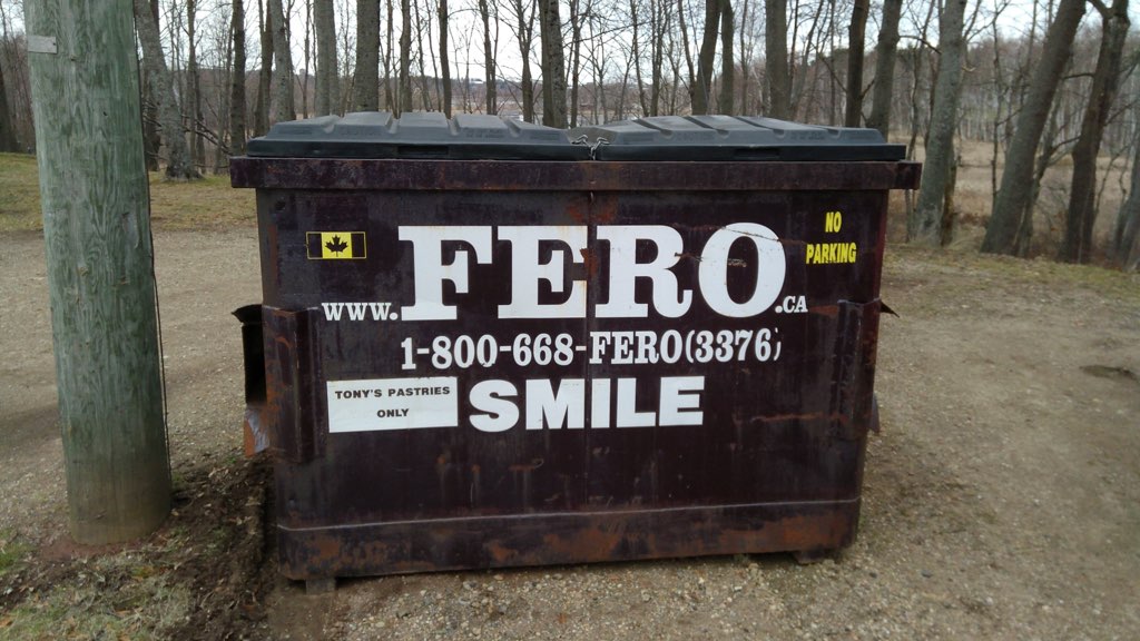 A FERO dumpster with the slogan "Smile" painted on it.