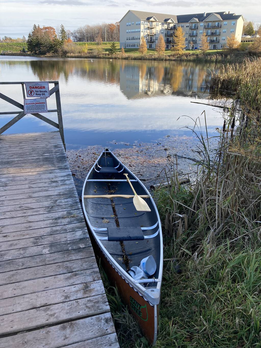 My canoe in the water by the dock at Andrews Pond North in the later afternoon sun.