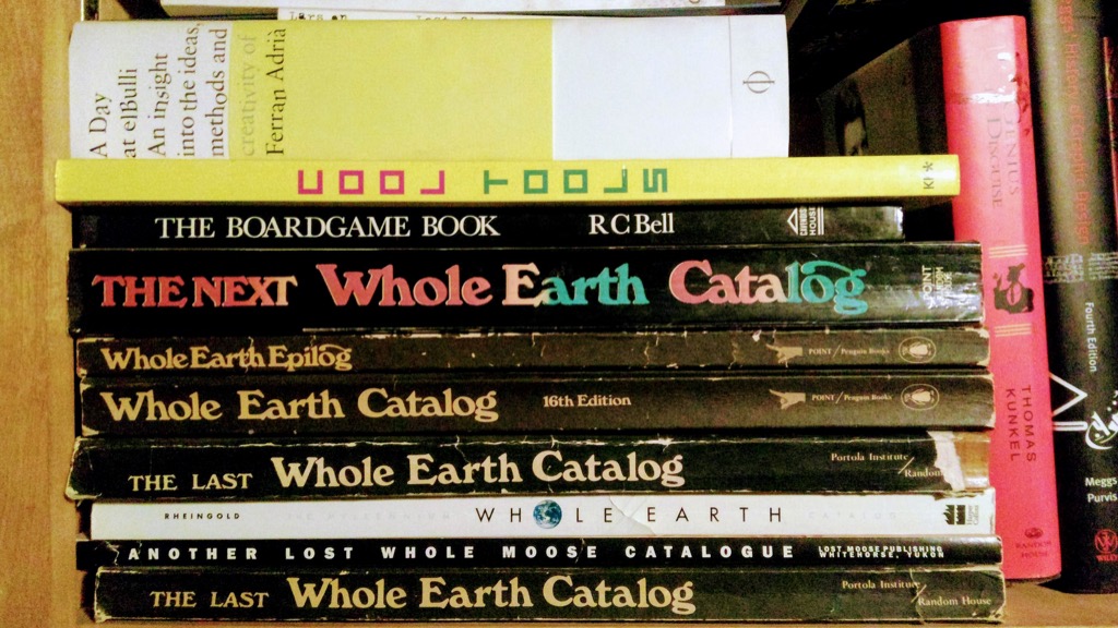 Photo of my collection of Whole Earth Catalogs, on my bookshelf.